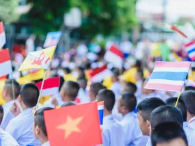 Obchody święta ASEAN. Grupa uczniów trzyma w rękach flagi państw Azji Południowo-Wschodniej.