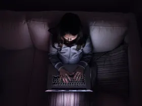 Dziewczyna korzystająca z laptopa w ciemnym pokoju