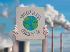 Człowiek trzymający znak z napisem „There's no planet B”
