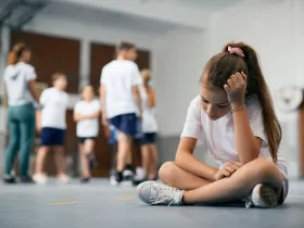 Smutna dziewczynka podczas lekcji wychowania fizycznego