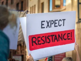 Dłonie trzymające baner na proteście