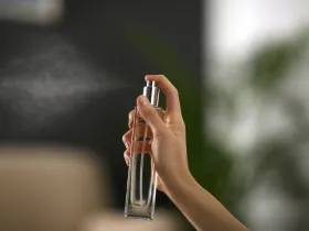 Ręka trzymająca butelkę perfum
