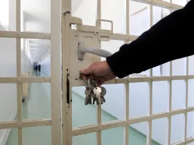 Człowiek otwierający drzwi do celi