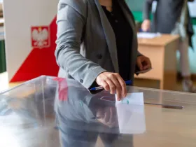 Kobieta wrzucająca kartę do głosowania do urny