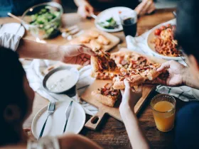 Grupa znajomych częstuje się pizzą