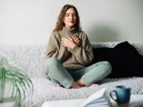 Kobieta praktykująca mindfulness na kanapie