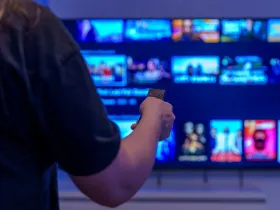 Kobieta trzymająca w ręku pilot od telewizora