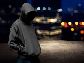 Mężczyzna w kapturze na ciemnej ulicy