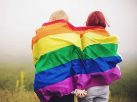 Kobiety owinięte tęczową flagą