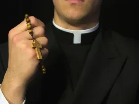 Ksiądz trzymający różaniec