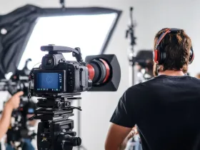  Człowiek w słuchawkach, nagrywa film w profesjonalnym studio z kamerą i oświetleniem