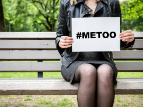 Kobieta trzymająca w rękach kartkę z napisem #MeToo