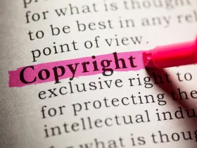 Słowo Copyright wyróżnione różowym markerem w tekście