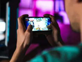  Osoba wpatruje się w ekran smartfona, grając w grę mobilną