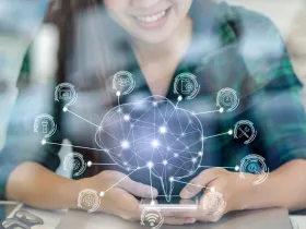Kobieta trzymająca w rękach telefon, nad nim hologram mózgu