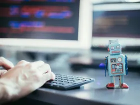 Figurka robota obok stanowiska komputerowego