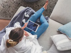 Kobieta siedząca na kanapie z tabletem