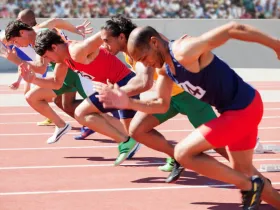 Sportowcy biegnący na torze
