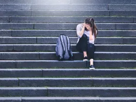 Smutna dziewczyna siedząca na schodach