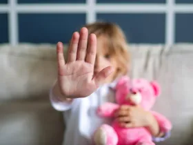 Mała dziewczynka pozakuje dłonią znak stop