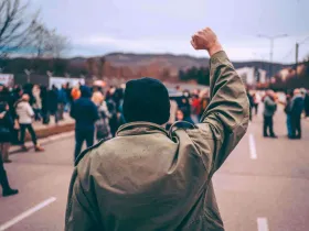 Mężczyzna protestuje na ulicy z podniesioną pięścią